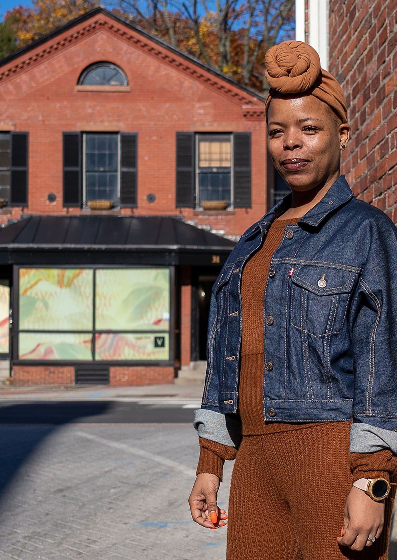 Leah Samura, a Black woman, stands outside what will be her new dispensary.