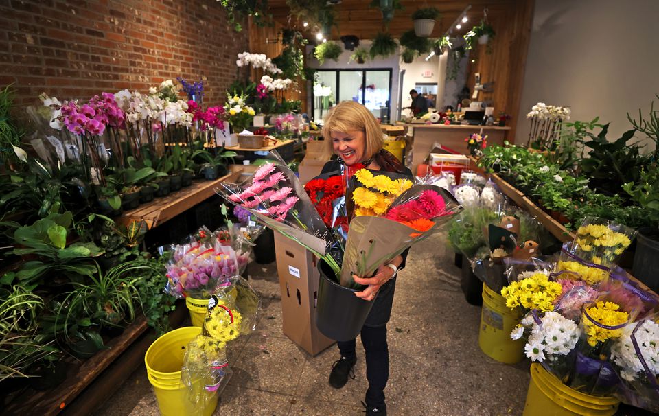 Employee Chris Antonellis took flowers out of the box at the Brattle Square Florist's new location at 52 Brattle Street which opened on Wednesday.