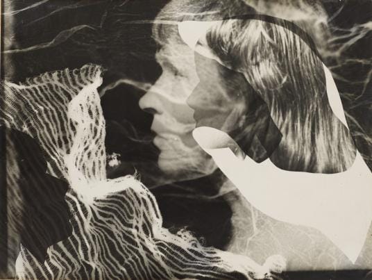 A black and white photogram with abstract patterns and silhouettes of faces and a hand.