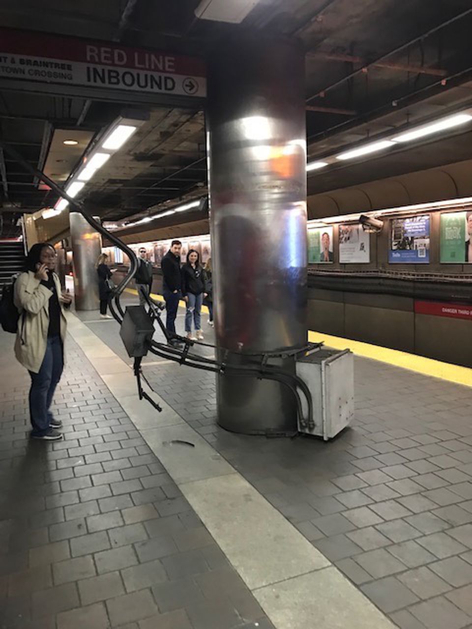 A piece of equipment fell from the top of a column at the Harvard MBTA station on Monday, striking a woman who was then taken to the hospital, officials said.