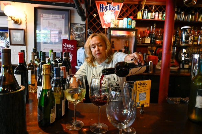 Rosaline Kovacs, co-owner, pours a glass of wine while working behind the bar at Shay's Pub & Wine Bar in Harvard Square in Cambridge, Friday, Aug. 11, 2023.