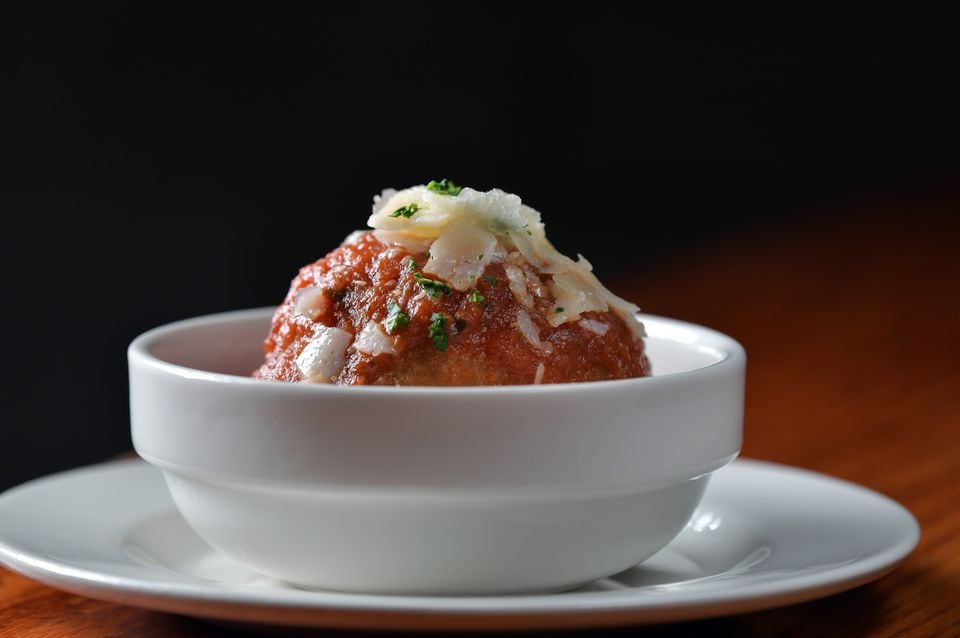 Wulf's Arancini, a deep-fried rice ball mixed with mushrooms and black olives, sitting in marinara sauce at Sea Hag Restaurant & Bar in Harvard Square.