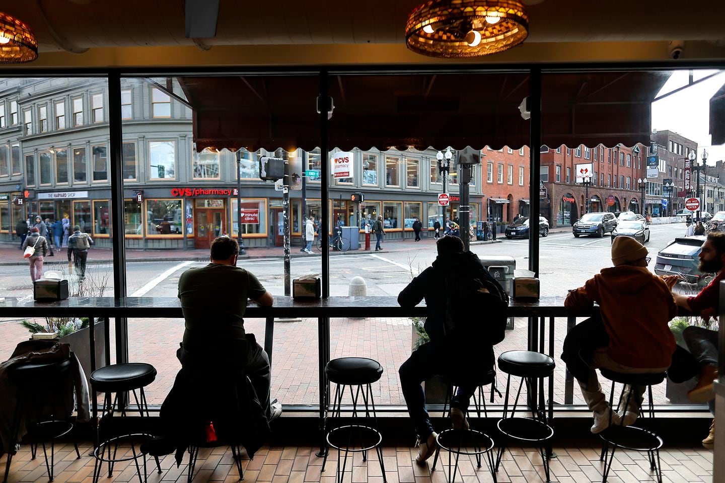 Customers look out onto Havard Square from their perch inside Joe’s Pizza.
