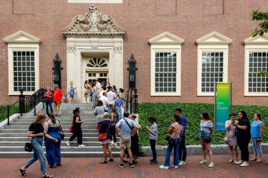 A group of people line up outside a museum.