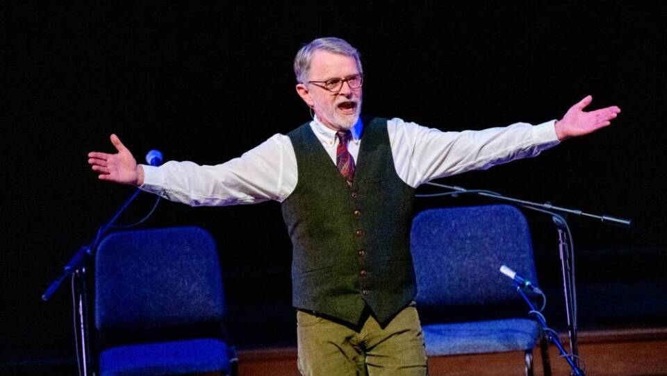 Brian O'Donovan pictured on stage during  a production of  "A St. Patrick's Day Celtic Sojourn,"  March 16, 2019. He's greeting the audience, with his arms outstretched.