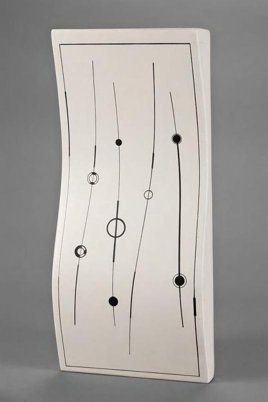 A rectangular sculpture features bold black geometric lines on a white undulating surface.
